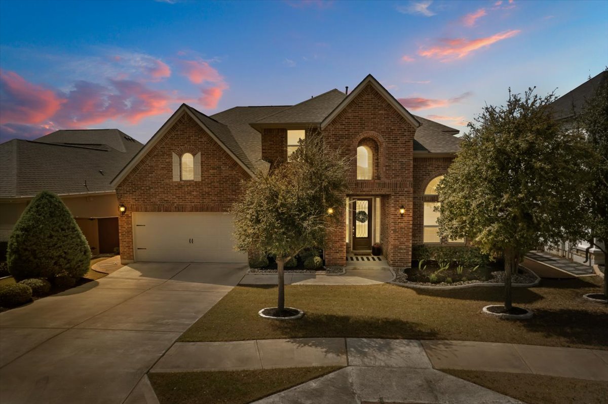 Brick house at sunset with lit driveway