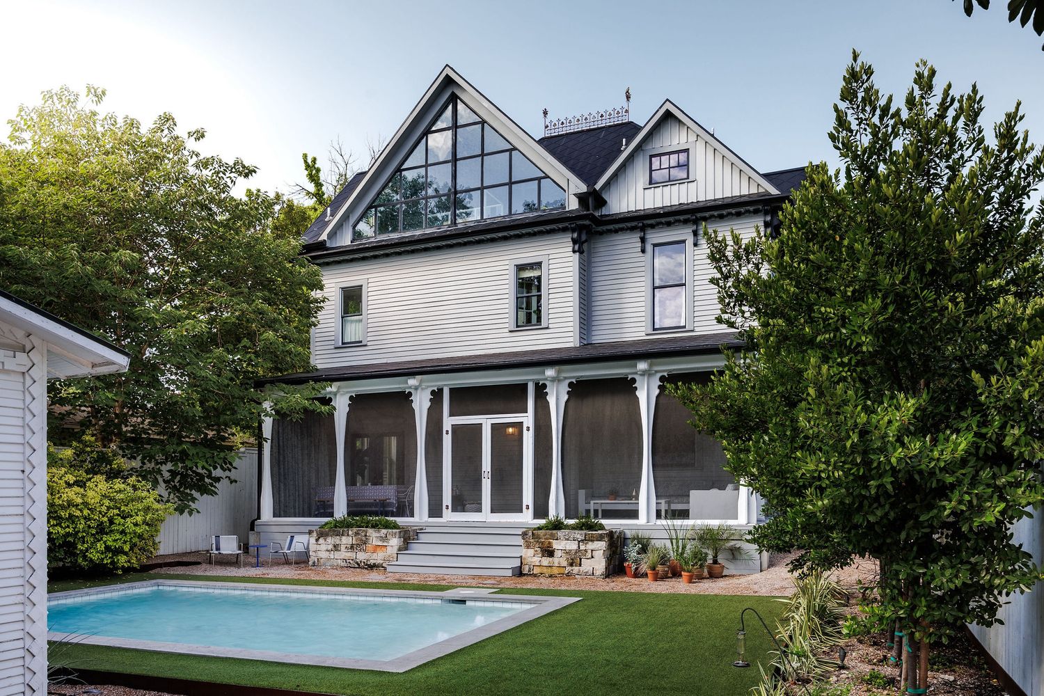 Victorian house with pool and lush garden.