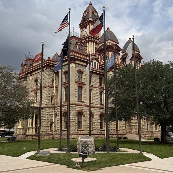 Historic courthouse with flags in front.