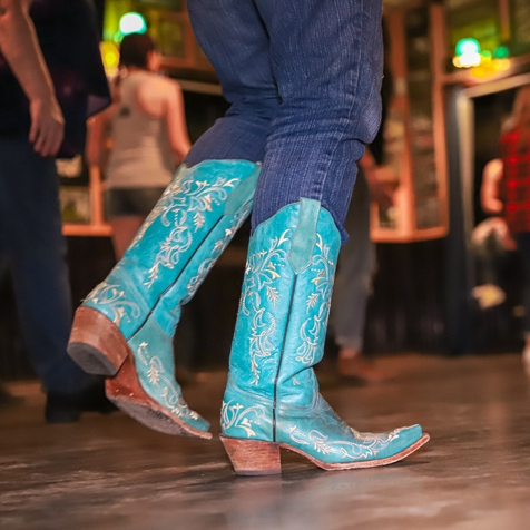 Dancing in turquoise cowboy boots, indoors.