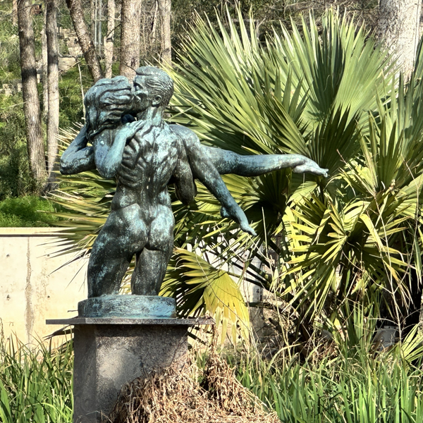 Bronze statue of entwined figures in garden
