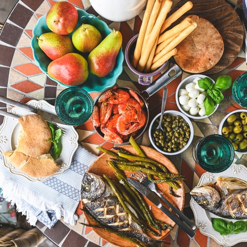 Mediterranean feast with fish, shrimp, and fresh produce.