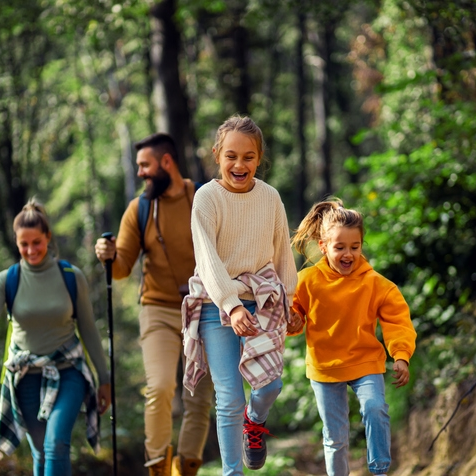 Family happily hiking in forest together