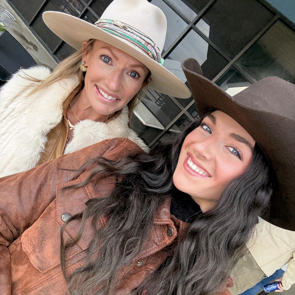Two smiling women in cowboy hats