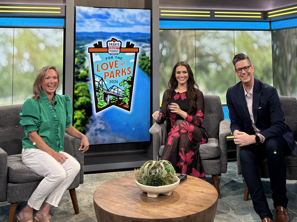 Three people seated on a talk show set