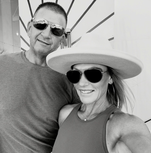 Smiling couple wearing sunglasses and hats.