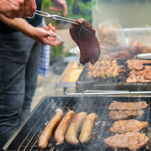 Rope Trix Person grilling steaks and sausages on barbecue