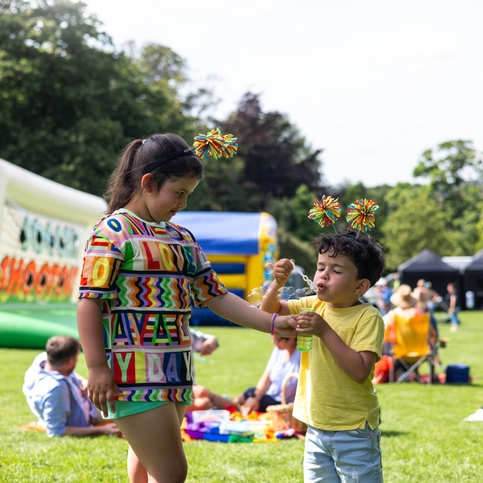 Children playing at a colorful outdoor festival.