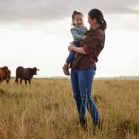 Mother and daughter in field with cows.