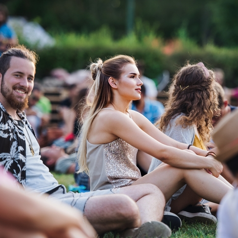 Young people sitting outdoors at an event.