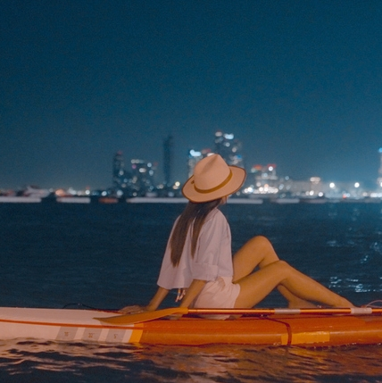 Woman on kayak at night in city waters
