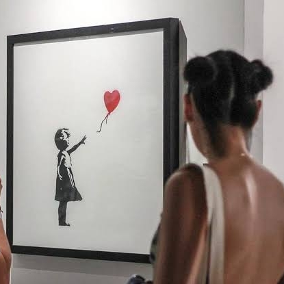 Rope Trix Woman viewing framed girl with red balloon artwork