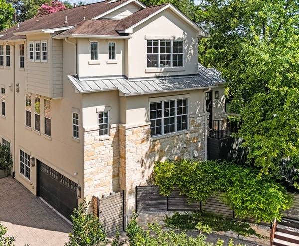 Modern three-story townhouse with stone facade and garage