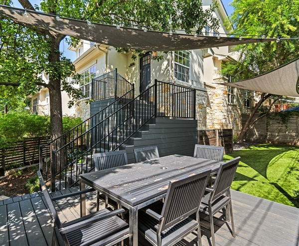 Modern backyard deck with dining table and stairs