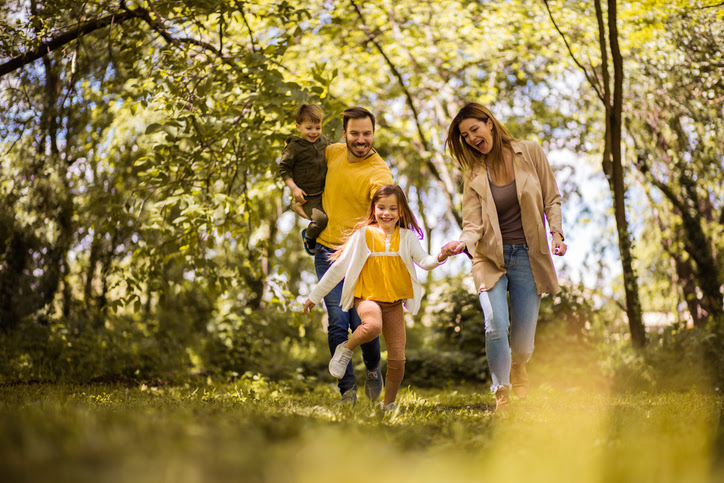 Family running together in sunny park