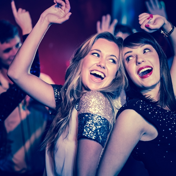 Two women laughing at a party.