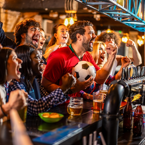 Friends cheering at bar with soccer ball