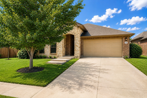 Brick suburban house with garage and tree-lined lawn