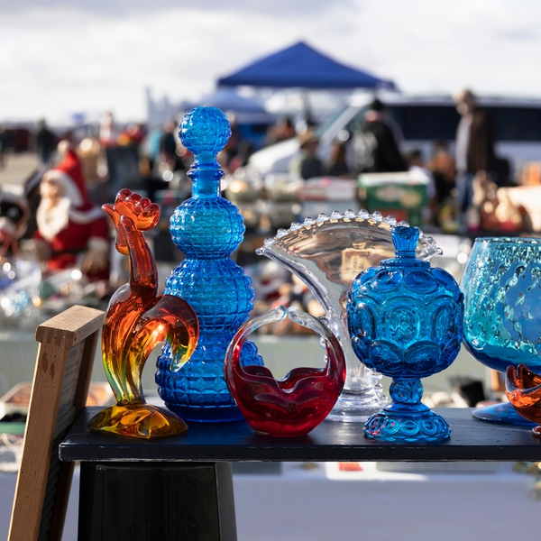Colorful vintage glassware displayed at an outdoor flea market
